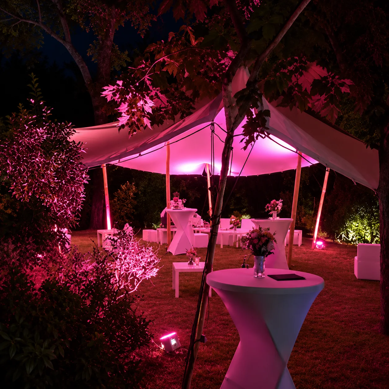 Salon de jardin nocturne sous un tente rose